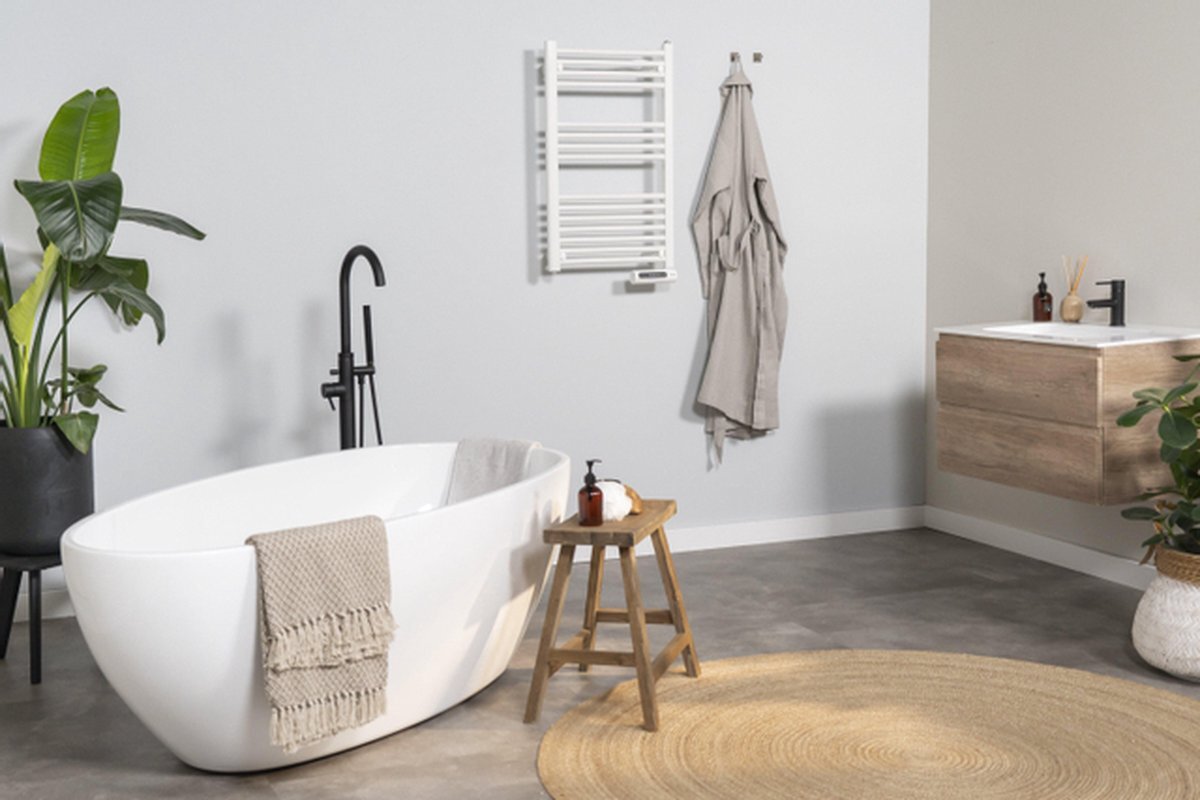 Modern bathroom featuring electric radiators, a freestanding tub, and indoor plants for optimal relaxation.