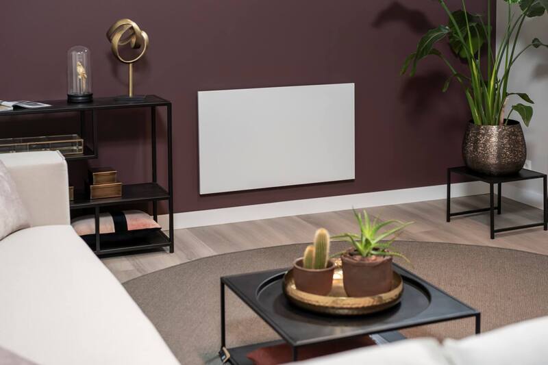 Sleek infrared heaters mounted on a wall in a modern living room, showcasing stylish decor and greenery.