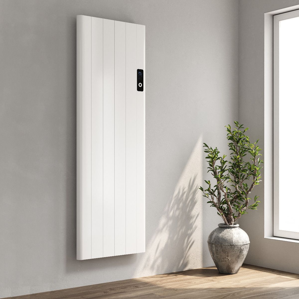 Vertical Electric Radiators mounted on a wall with a potted plant beside it in a stylish interior setting.