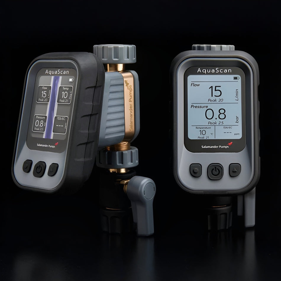 Two Salamander AquaScan digital flow and pressure meters with gray protective housings and gold-toned connectors, shown on a black studio background.