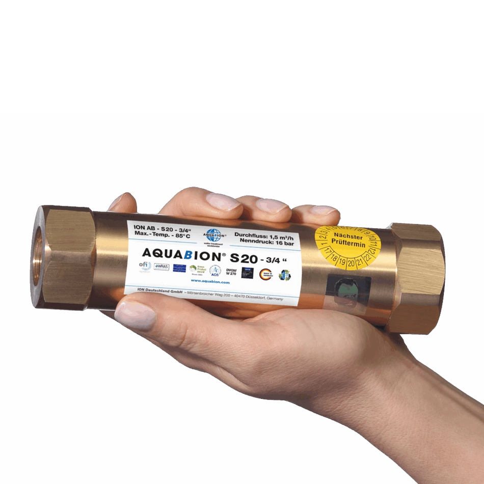 Hand holding a brass plumbing component with Aquabion branding on a white background