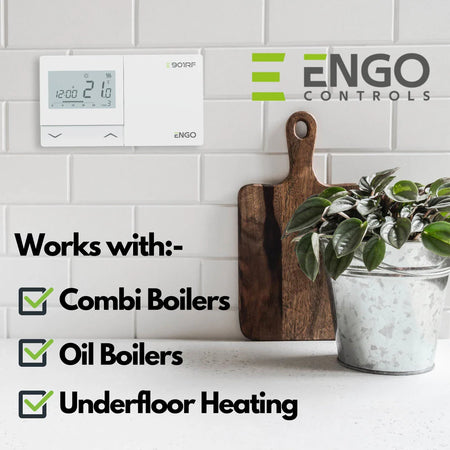 Digital thermostat on a wall with ENGO Controls branding, featuring text about compatible heating systems.