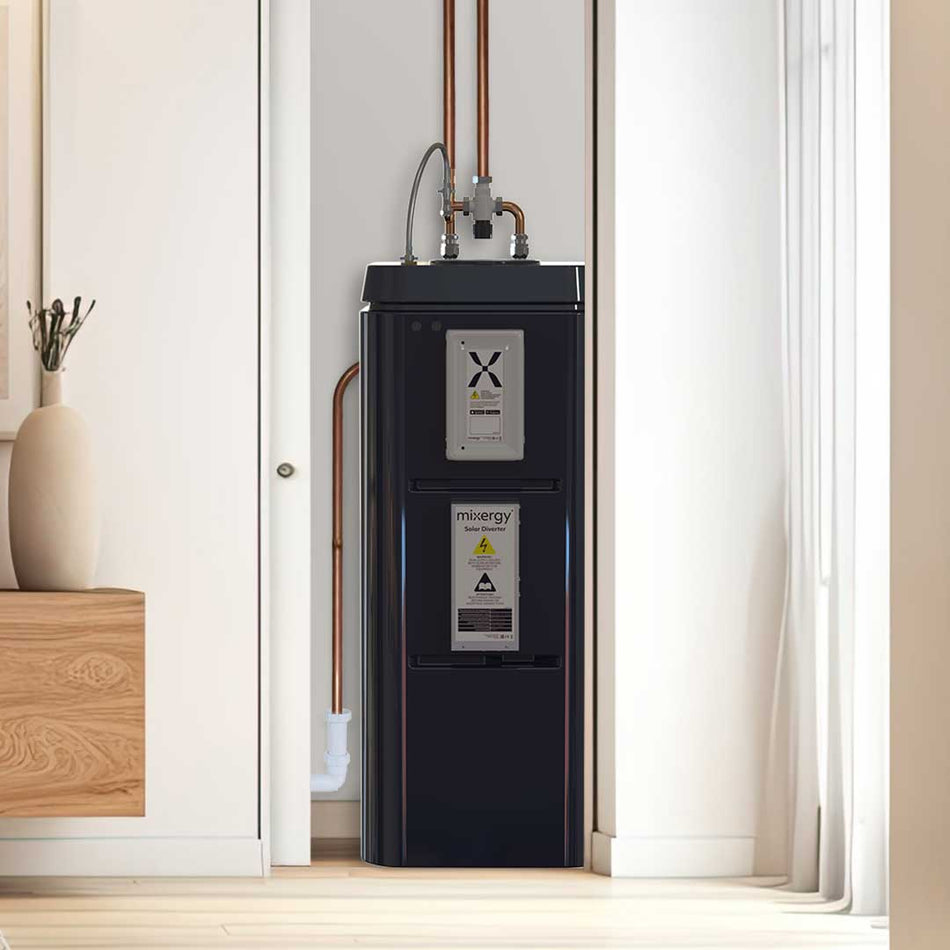 Black water heater in a room with white walls and wooden floor.