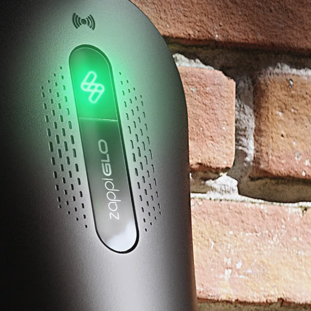 ZappiGLO device with green light indicator against a brick wall background