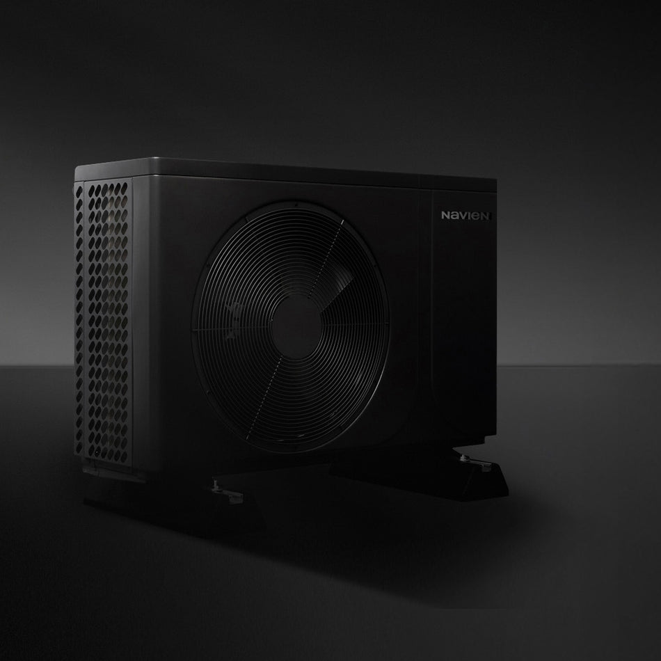 A black outdoor Navien heat pump outdoor unit with a large front fan, side ventilation grille, and a small visible 'NOVIEN' logo on a dark studio background.