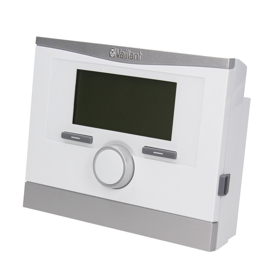 A Vaillant gas boiler or central heating control panel with a white faceplate, silver trim, a central rotary dial, and a dark display screen, shown on a plain white background.