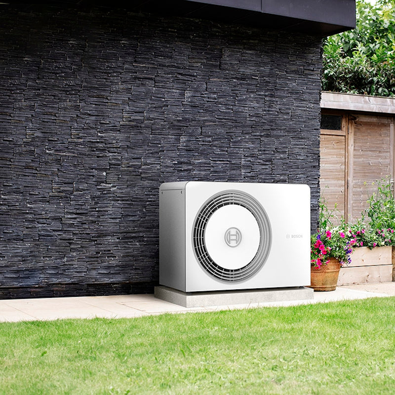 Worcester Bosch Compress 5800i AW Heat Pump outdoor unit installed in a garden setting.