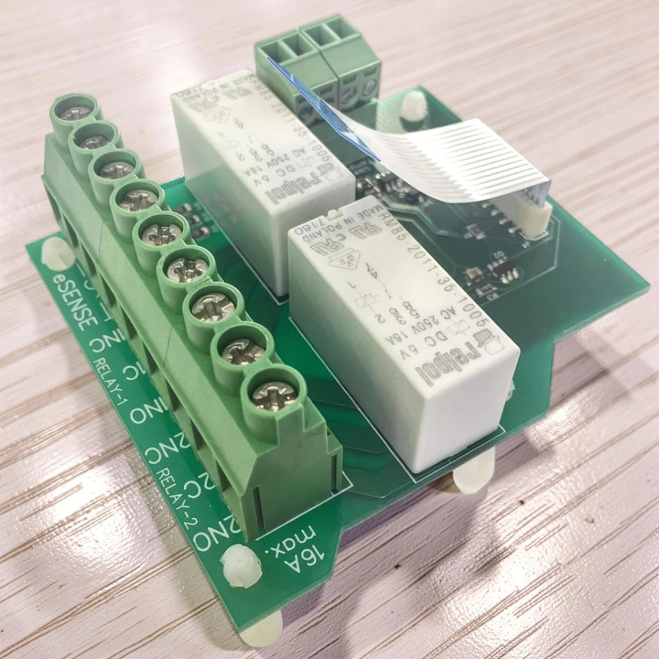 Electronic relay module of myenergi eddi with green housing on a wooden surface